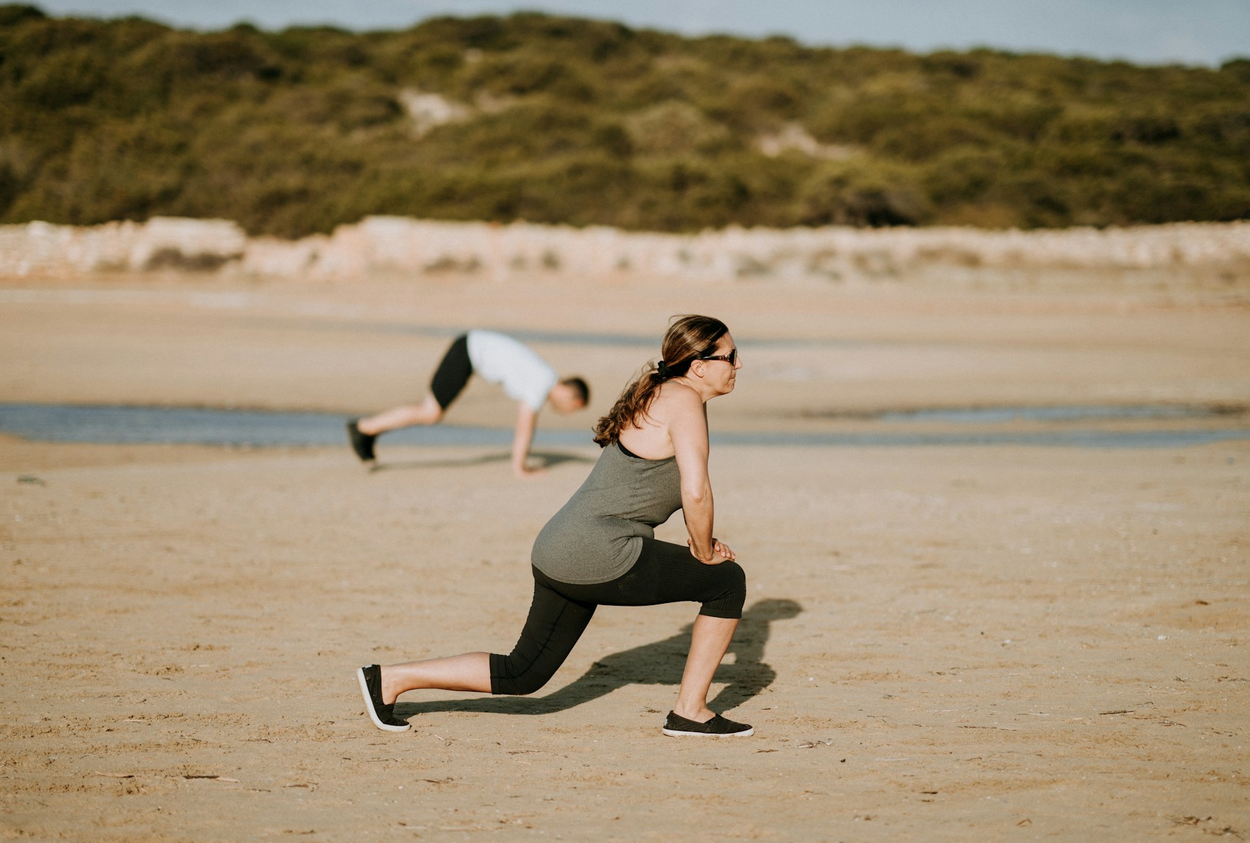 An adult practicing a controlled lunge during an outdoor training session
