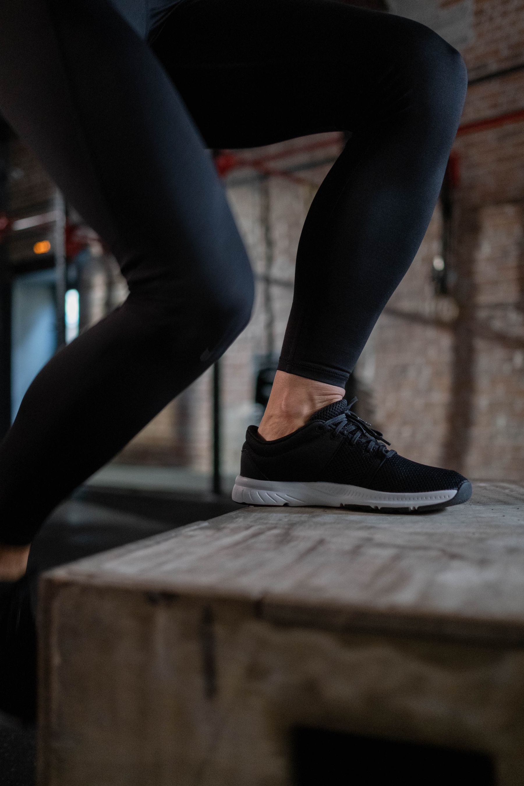An athlete stepping onto a plyometric box during a movement assessment