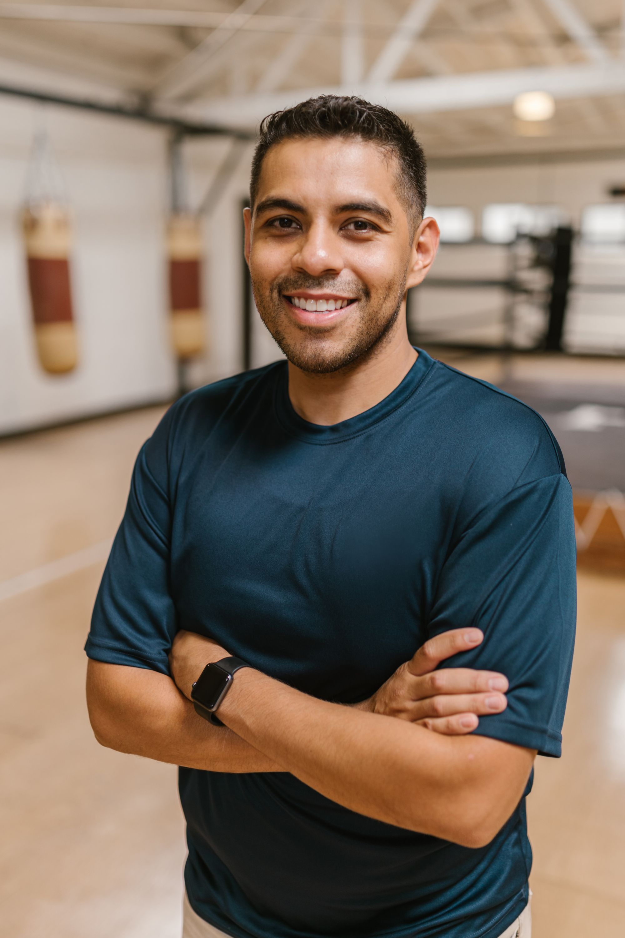 A younger professional fitness coach in a bright training studio